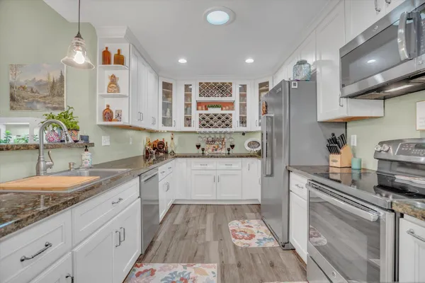 a large kitchen with stainless steel appliances granite countertop a sink and cabinets