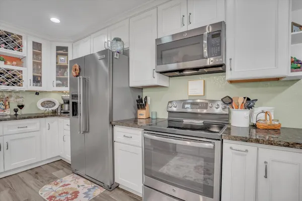 a kitchen with stainless steel appliances granite countertop a refrigerator stove and sink