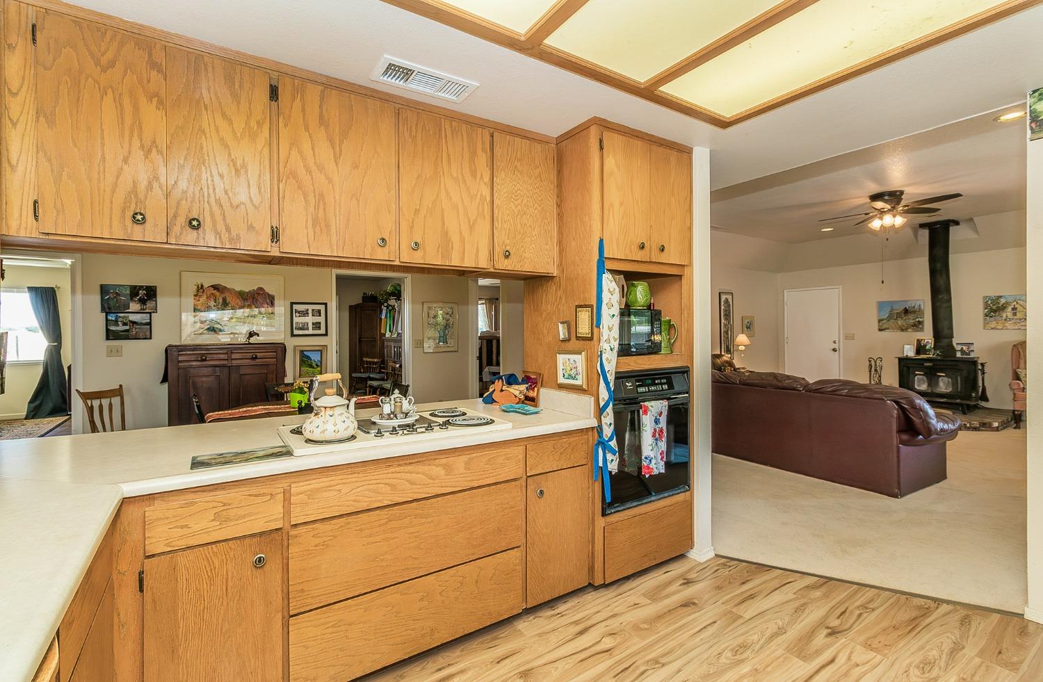 13016 Violet Lane Clovis, CA 93619 - Photo 14 of 41 a kitchen with kitchen island granite countertop a sink cabinets and wooden floor