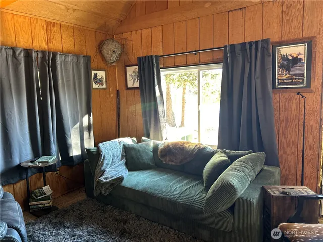 a living room with furniture a window and a flat screen tv