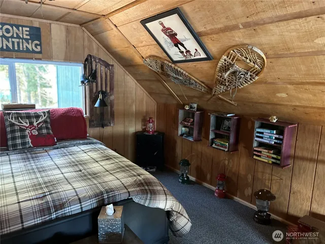 a bedroom with bed and wooden floor