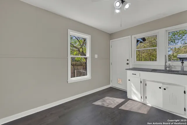 an empty room with windows and cabinet