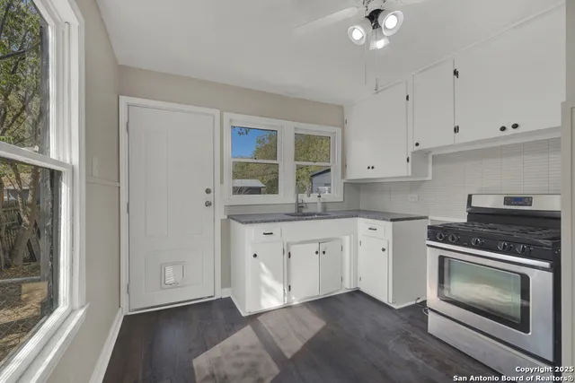 a kitchen with granite countertop white cabinets stainless steel appliances and a sink