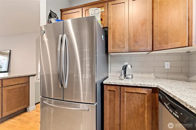 a kitchen with stainless steel appliances granite countertop a refrigerator and a sink