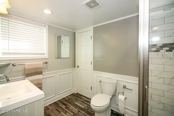 a bathroom with a sink a toilet and shower