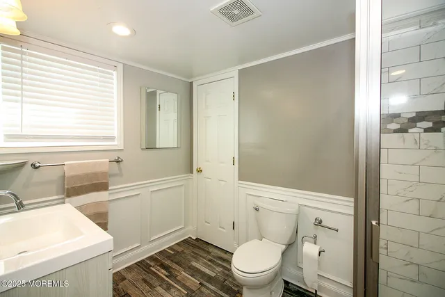 a bathroom with a sink a toilet and shower