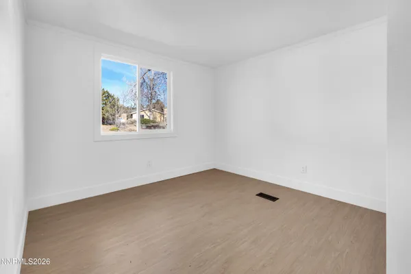 an empty room with a painting on the wall