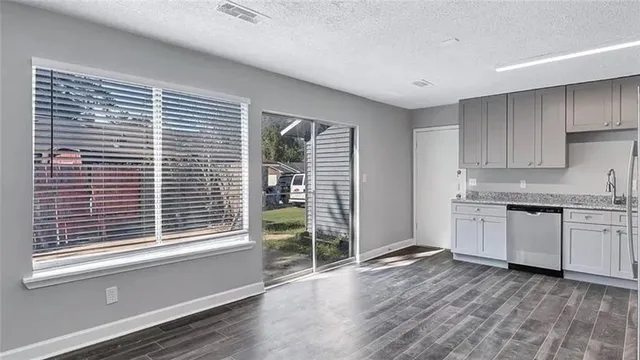 a kitchen with granite countertop a stove a sink and a large window