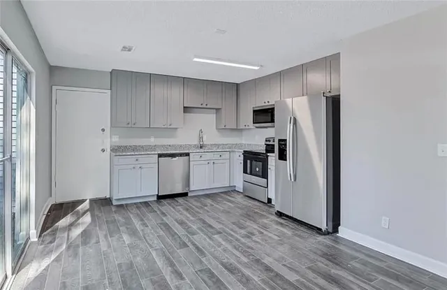 a kitchen with stainless steel appliances a refrigerator sink and cabinets