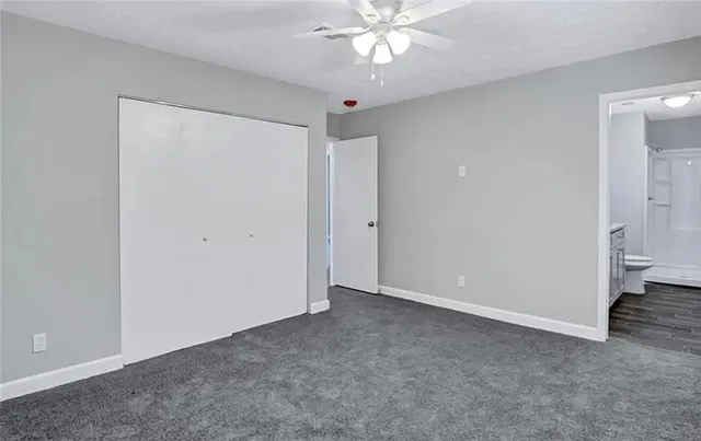 a view of an empty room and chandelier fan