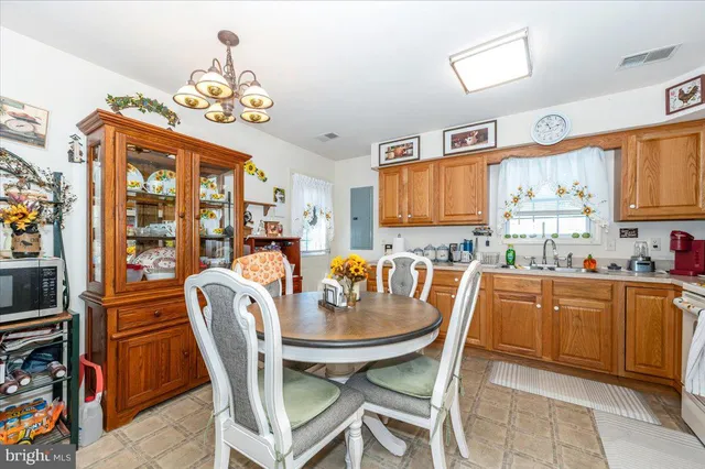 a dining room with stainless steel appliances granite countertop a dining table chairs and a refrigerator