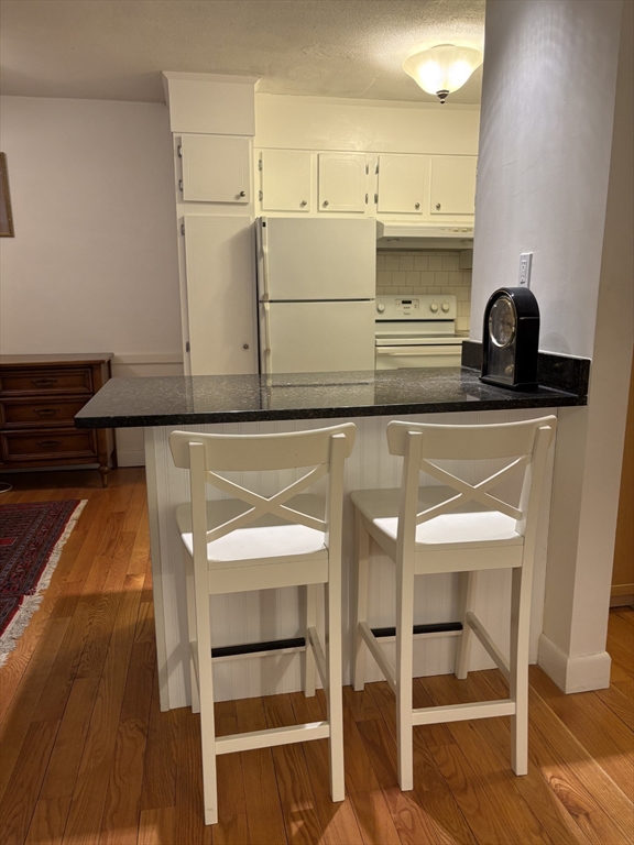 73 Walnut Street, Unit 6 Newton, MA 02460 - Photo 4 of 11 a kitchen with cabinets and chairs