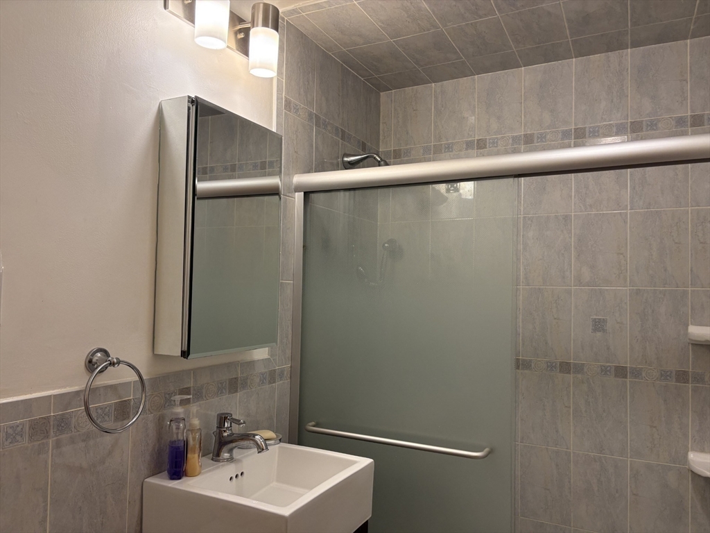 73 Walnut Street, Unit 6 Newton, MA 02460 - Photo 8 of 11 a bathroom with a sink and mirror