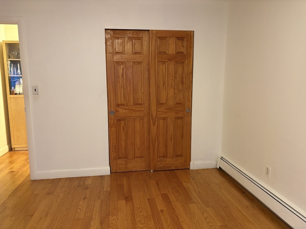 73 Walnut Street, Unit 6 Newton, MA 02460 - Photo 10 of 11 an empty room with wooden floor and closet area