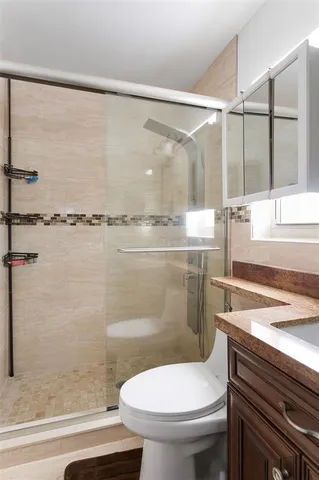 a bathroom with a sink a toilet and shower
