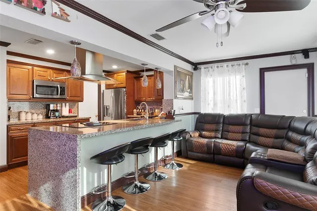 a living room with stainless steel appliances kitchen island granite countertop furniture and a kitchen view