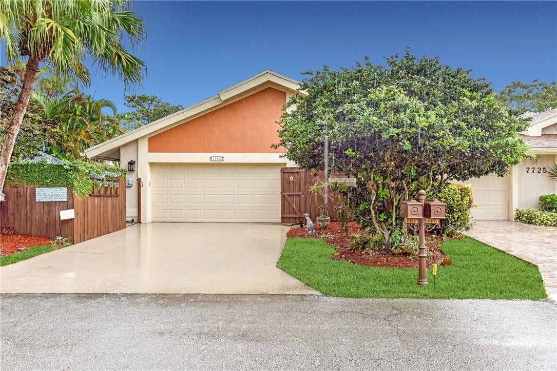 7735 Stanway Place, Unit 7735 Boca Raton, FL 33433 - Photo 1 of 34 a view of a white house with a yard and potted plants