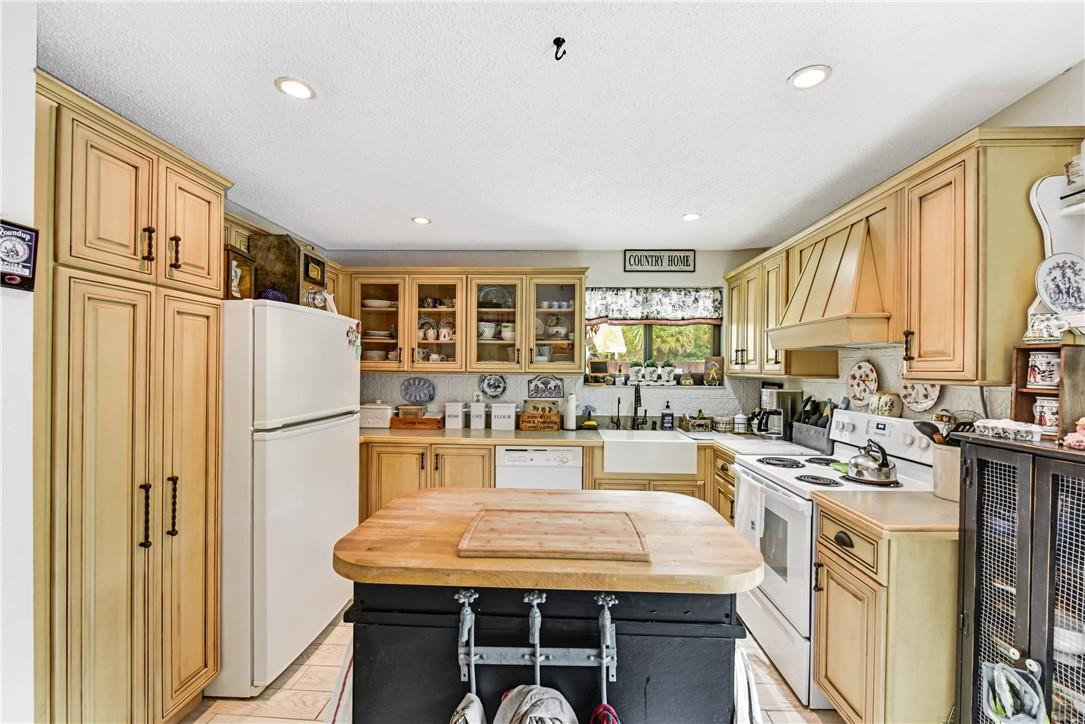 7735 Stanway Place, Unit 7735 Boca Raton, FL 33433 - Photo 14 of 34 a kitchen with stainless steel appliances granite countertop a stove a refrigerator a kitchen island a stove and a refrigerator