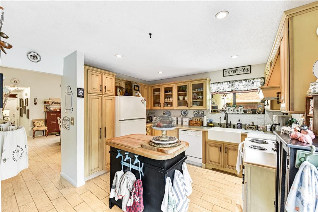 7735 Stanway Place, Unit 7735 Boca Raton, FL 33433 - Photo 15 of 34 a kitchen with a refrigerator a stove and a dining table with wooden floor