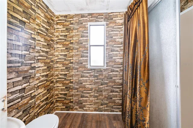 a view of a room with wooden floor and furniture