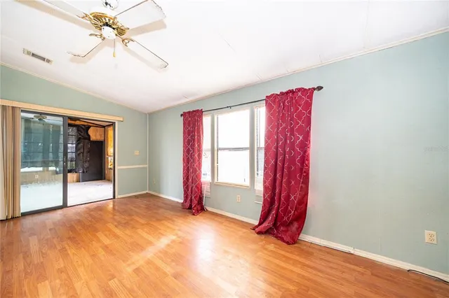 a view of an empty room with wooden floor