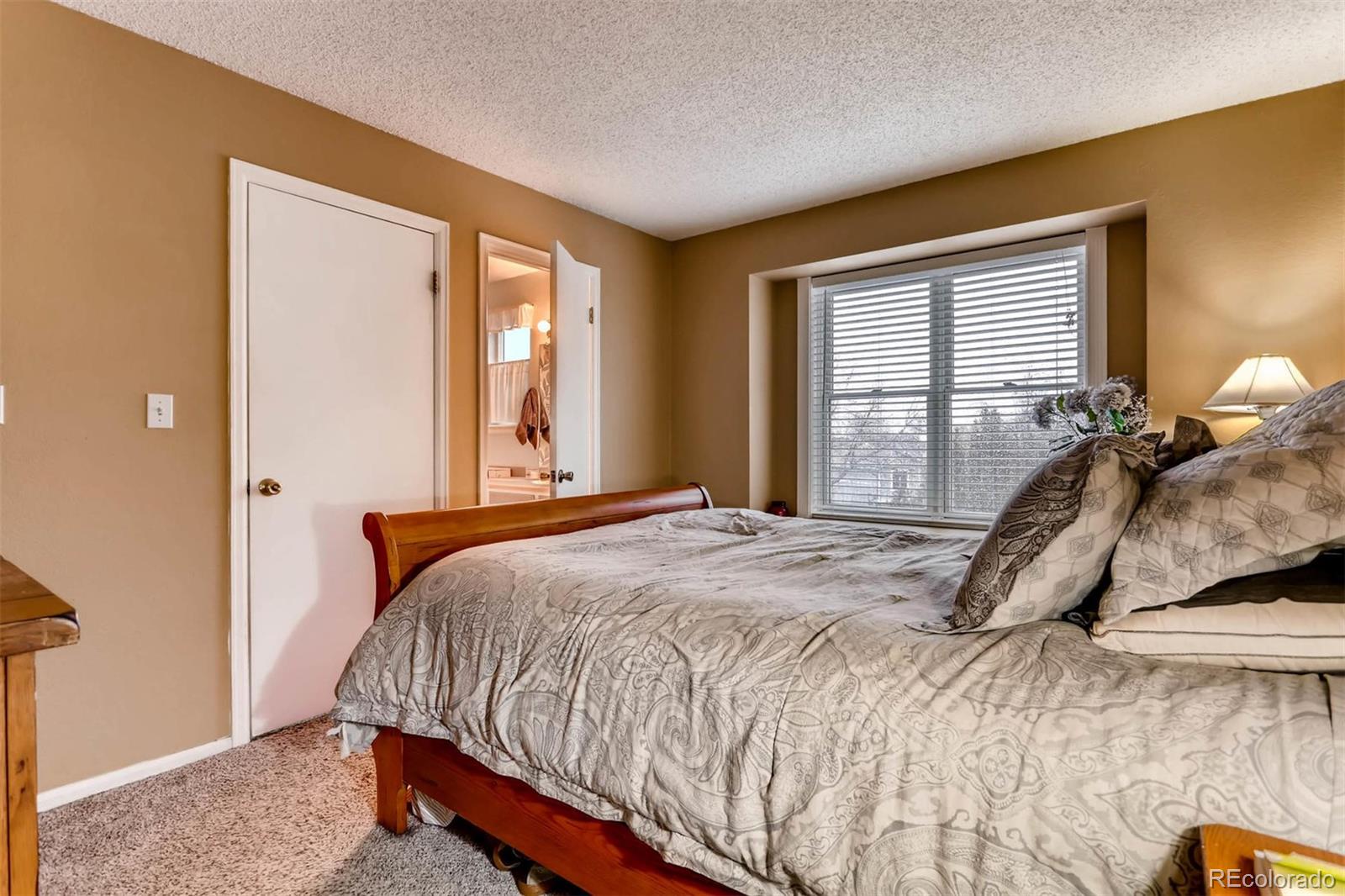 696 Myrtlewood Court Highlands Ranch, CO 80126 - Photo 7 of 12 a bed sitting in a bedroom next to a window