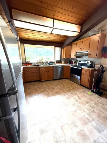 a kitchen with stainless steel appliances wooden cabinets a sink and a stove