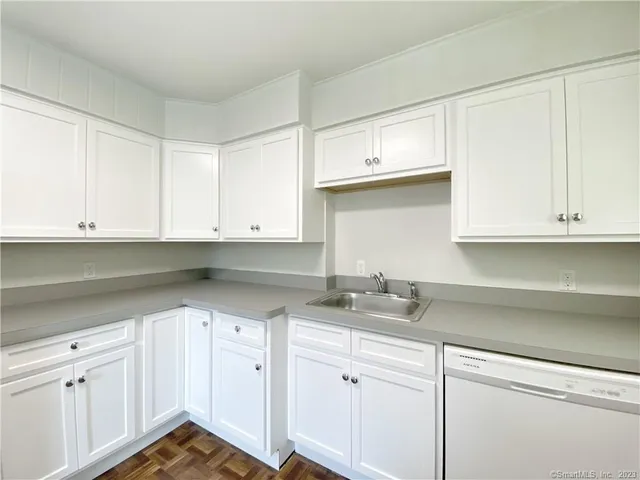 a kitchen with granite countertop white cabinets and white appliances