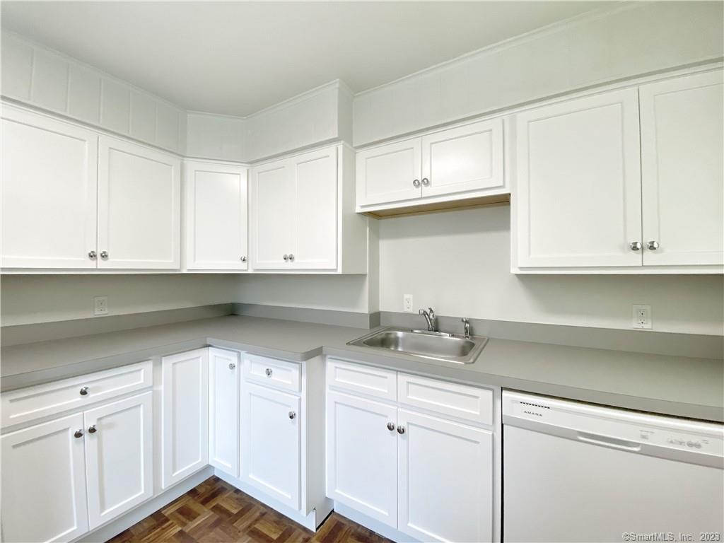 a kitchen with granite countertop white cabinets and white appliances