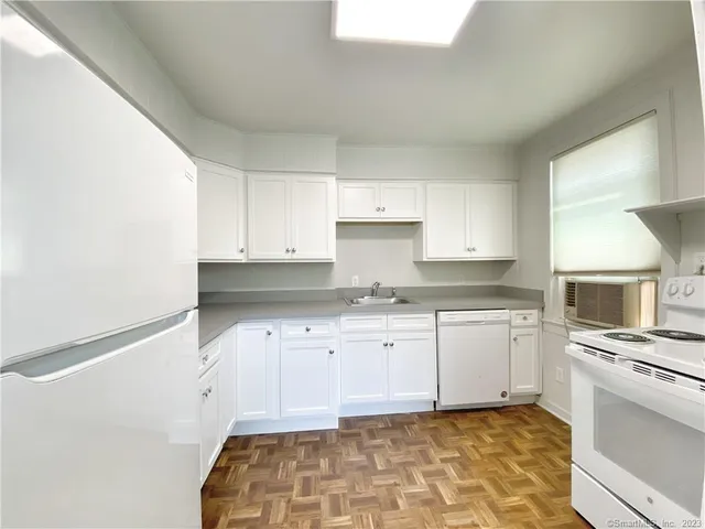 a kitchen with granite countertop a sink stove and cabinets