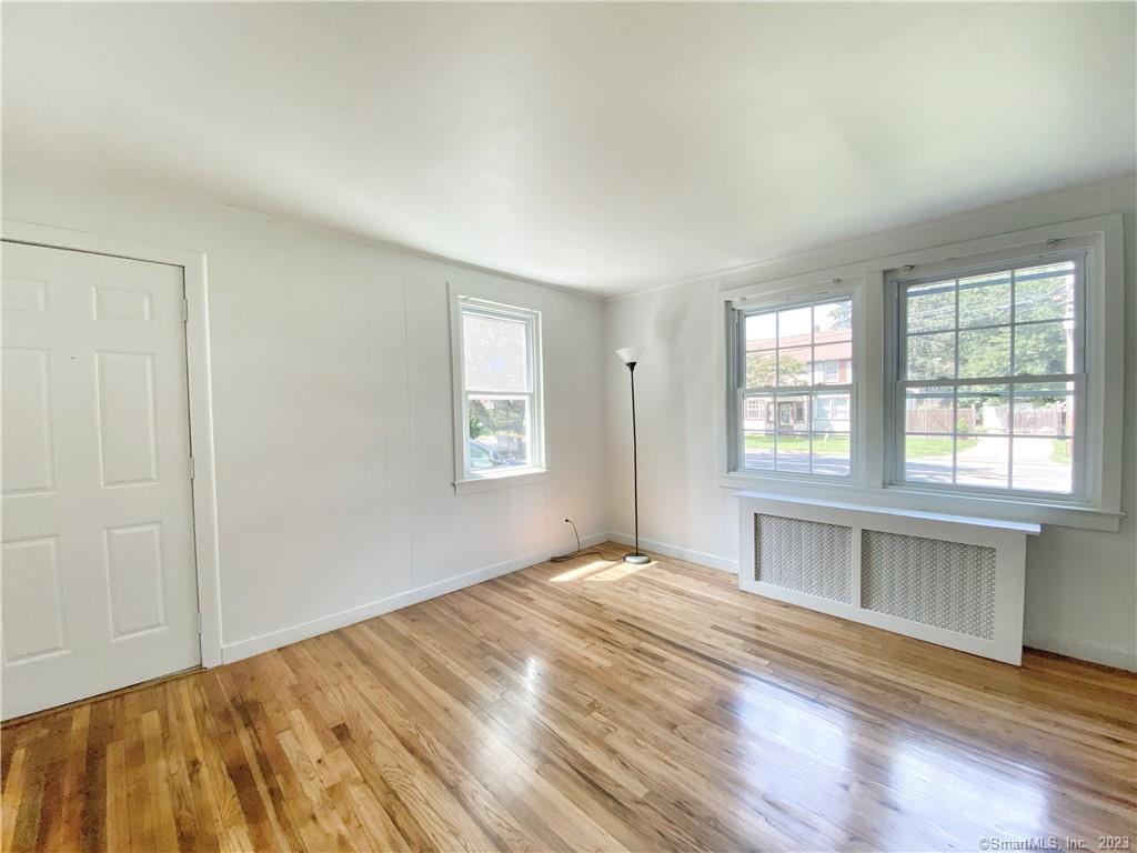 251 Melville Drive Fairfield, CT 06825 - Photo 3 of 8 an empty room with wooden floor and windows