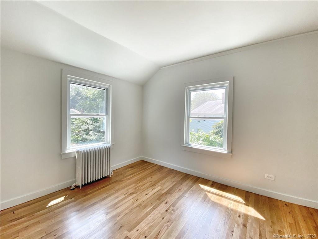 251 Melville Drive Fairfield, CT 06825 - Photo 6 of 8 a view of an empty room with wooden floor and a window