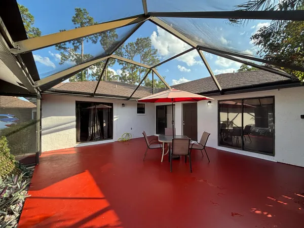 a view of a patio with table and chairs under an umbrella