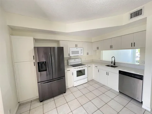 a kitchen with stainless steel appliances a refrigerator sink and cabinets