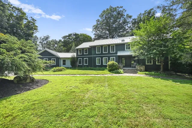 a front view of a house with swimming pool having outdoor seating