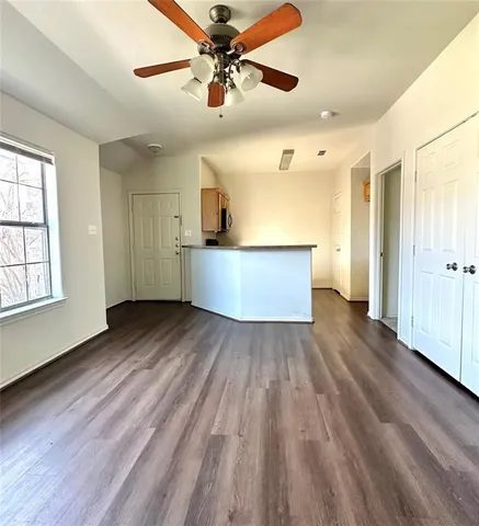 a view of empty room with wooden floor
