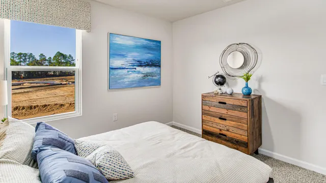 a bedroom with a bed and painting on the wall