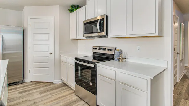 a kitchen with white cabinets and sink