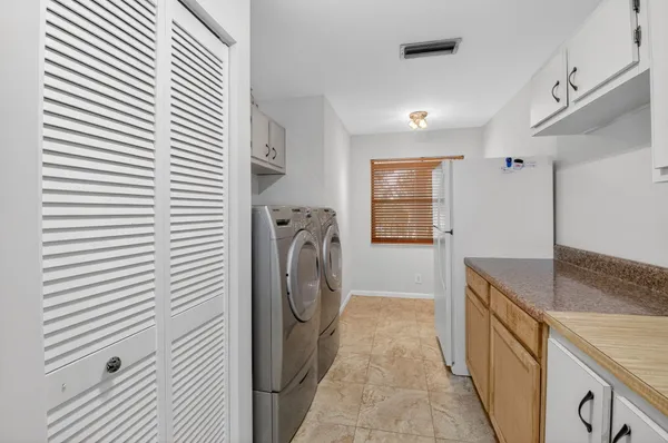 a kitchen with white cabinets and white appliances