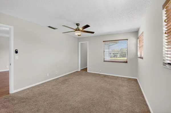 a view of an empty room with a ceiling fan