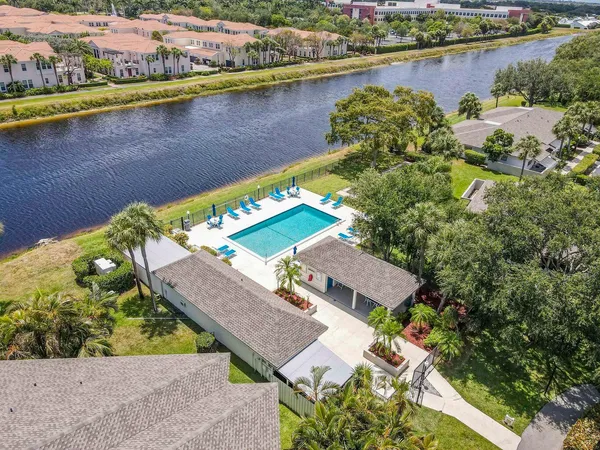 a view of swimming pool with outdoor seating and trees in the background