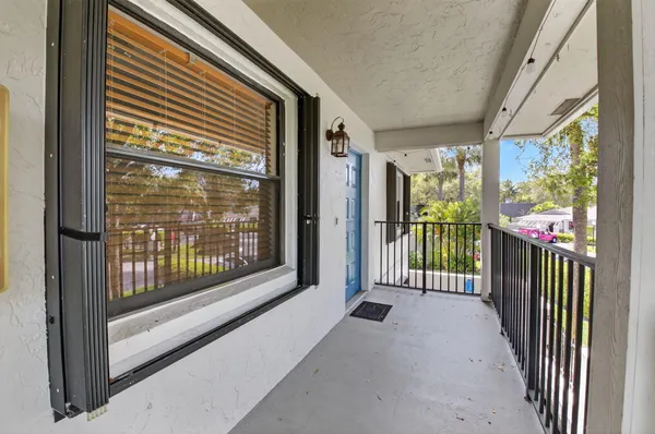 a view of a porch with wooden floor and floor to ceiling window