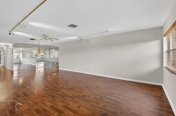 an empty room with wooden floor and windows