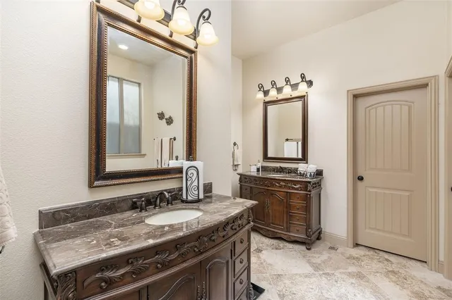 a bathroom with a granite countertop tub sink and mirror