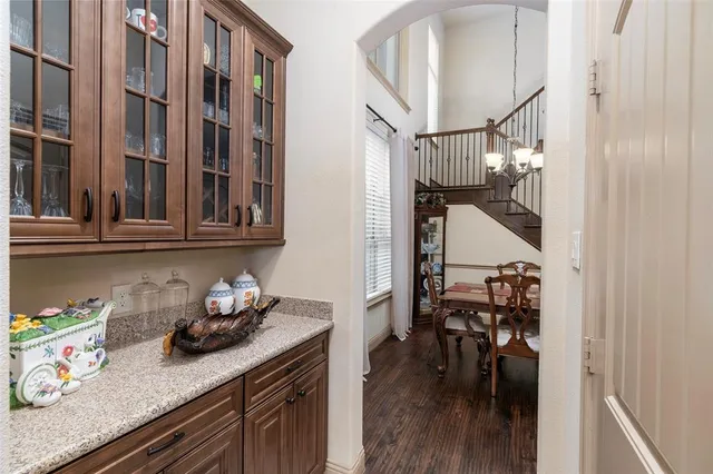 a kitchen with stainless steel appliances granite countertop a lot of cabinets and wooden floor