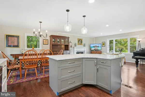 a open kitchen with stainless steel appliances granite countertop a stove and a wooden floors