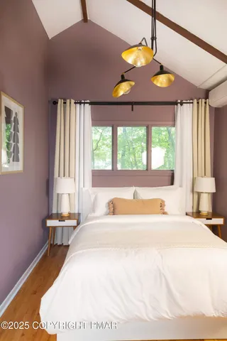 a bedroom with a bed and a large window