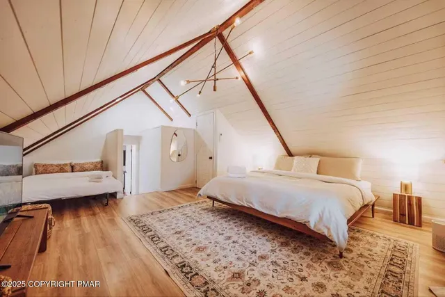 a spacious bedroom with a bed table and a window