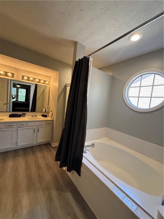 4949 Penscot Way Stone Mountain, GA 30088 - Photo 34 of 40 a bathroom with a tub a sink and a mirror