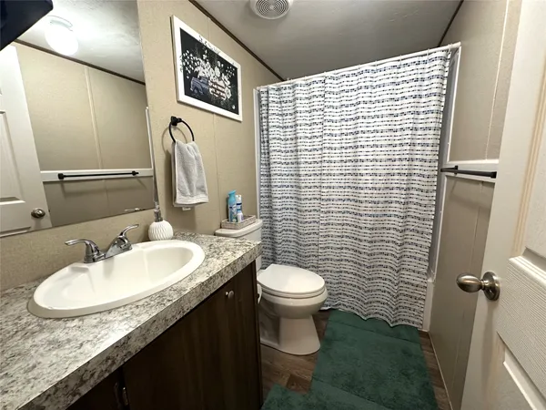 a bathroom with a granite countertop sink toilet and shower